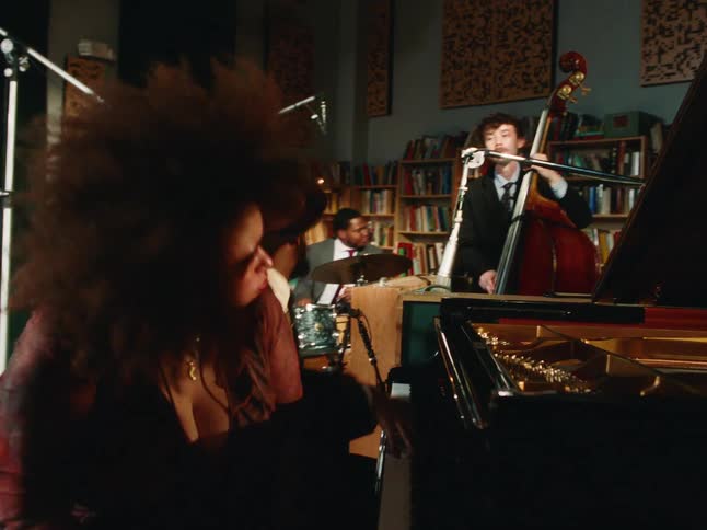 An expressive jazz quartet passionately performs together in a cozy, book-lined recording studio