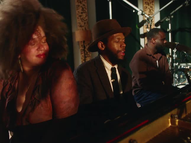 A soulful trio of musicians get lost in the music, playing piano and singing together in a vintage recording studio
