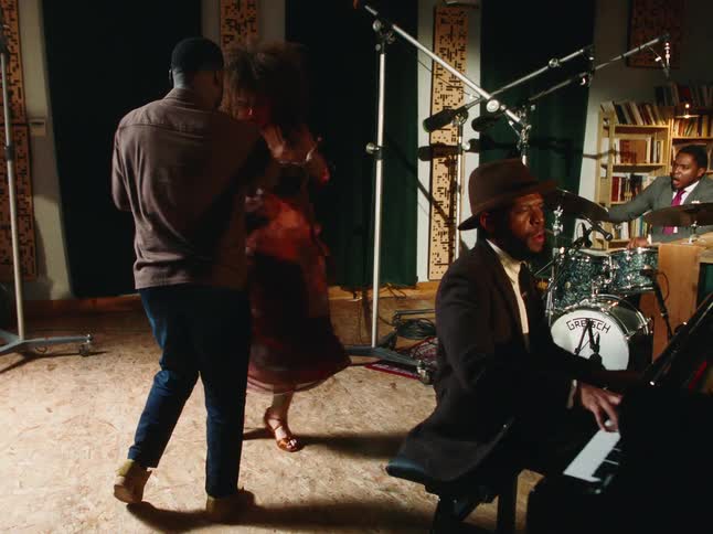 A soulful couple dances passionately while a jazz trio performs in a vintage-style recording studio