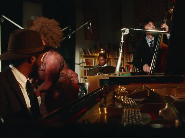 A soulful jazz quartet performs an energetic set in an intimate, dimly lit studio filled with books