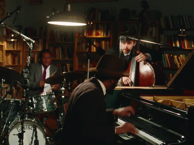 A stylish jazz trio passionately performs in a cozy, book-lined studio