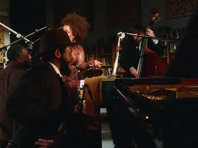 A soulful jazz quartet featuring a female vocalist performs in an intimate, dimly lit recording studio