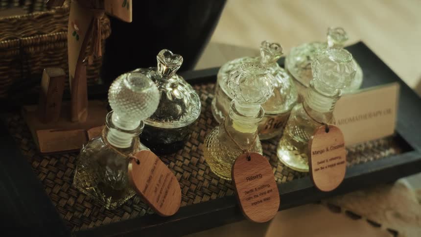 A close-up shot of elegant glass bottles filled with various aromatherapy massage oils on a tray in a spa