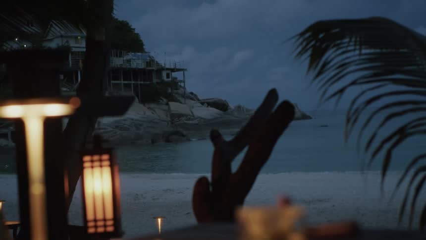 A pot of fresh mint tea steeps on a table at a luxurious beachside resort during a tranquil evening