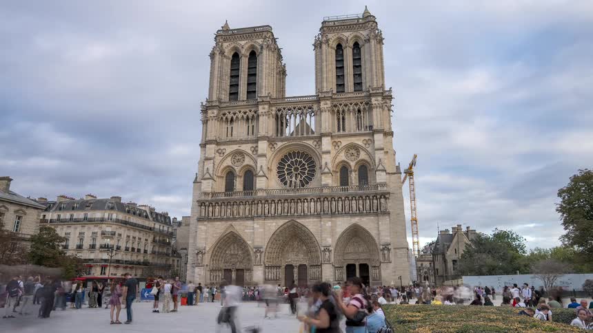 A long exposure timelapse of crowds of tourists walking in front of the iconic Notre Dame Cathedral in Paris, France