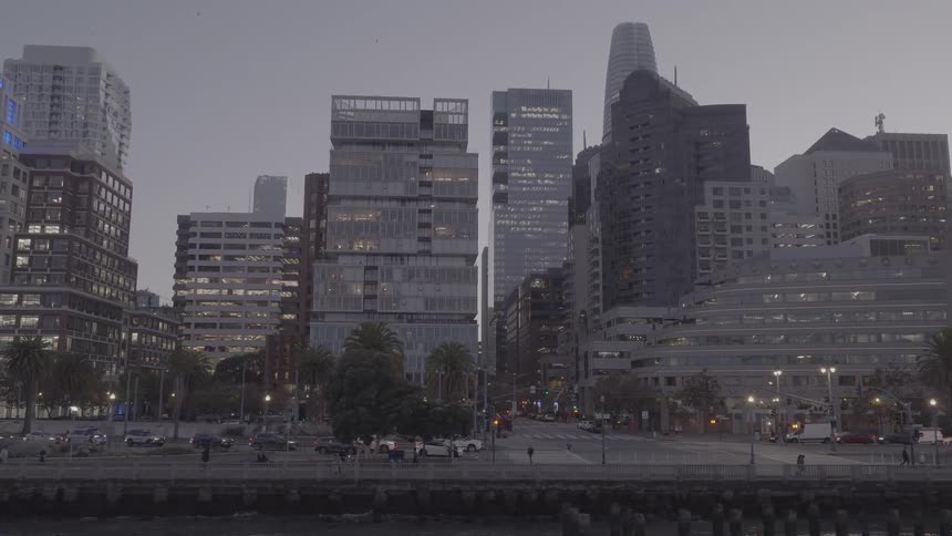 A slow right pan of the modern San Francisco skyline and the Embarcadero at twilight