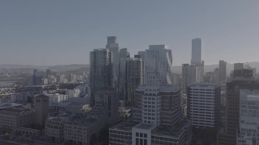 Slow aerial push-in towards the downtown San Francisco skyline and waterfront on a clear, sunny day