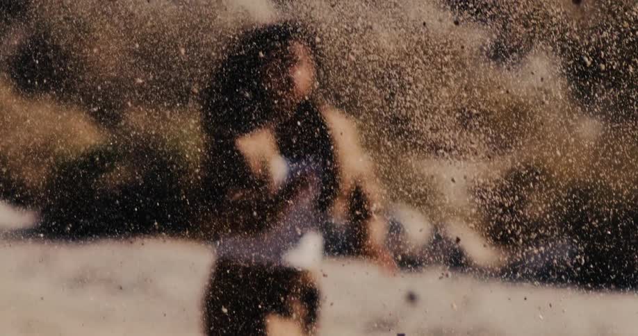 Fine sand particles dance through the air in a super slow-motion, abstract visual