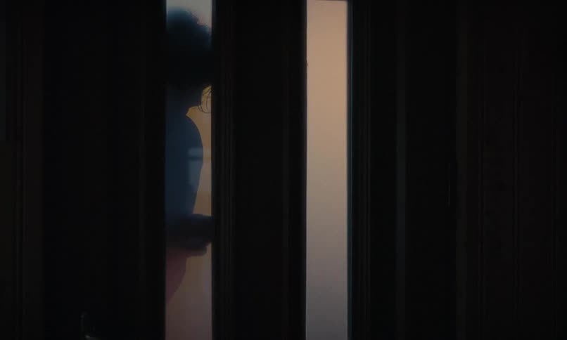 A woman opens the door and gives a comforting, emotional hug to a weary man returning home at dusk