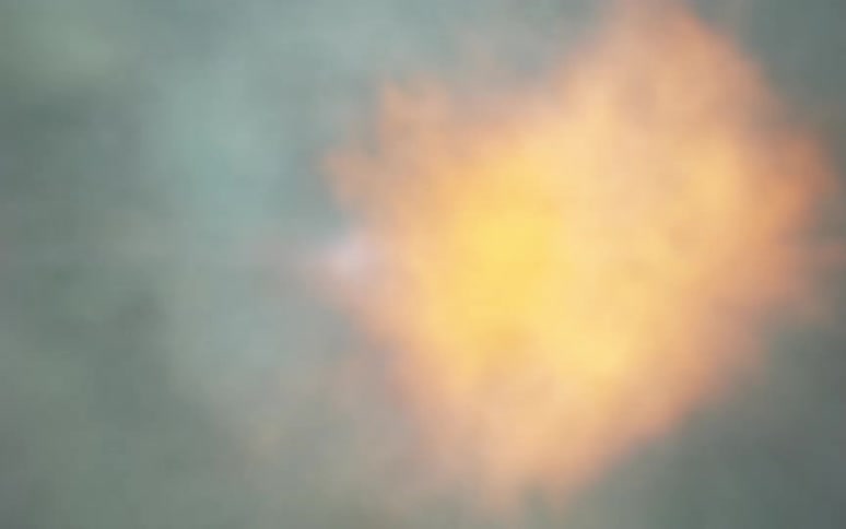 An intense slow-motion macro shot captures a gun firing, revealing a brilliant muzzle flash and an expanding cloud of smoke