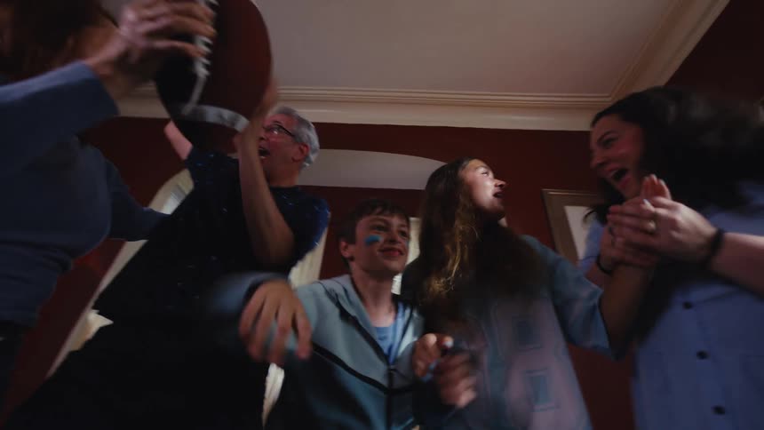 From tense anticipation to explosive celebration, a multi-generational family cheers for their favorite football team's victory at home