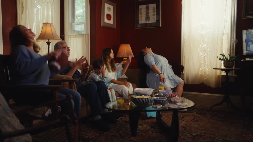 A family of devoted sports fans reacts with shock and disappointment after their team loses the game while watching from their living room