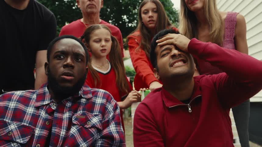 A diverse group of friends and family react with disappointment and frustration as they watch their sports team lose a game in their backyard