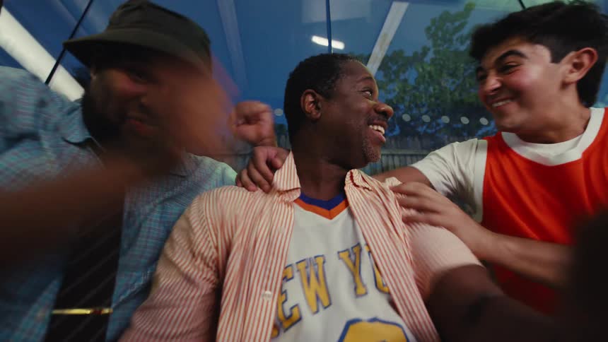 A diverse group of friends anxiously watch a sports game, erupting into a joyous celebration when their team scores the winning point