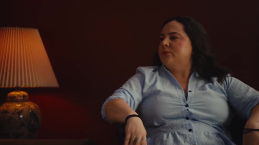 An emotional mother prays and gestures dramatically while her disappointed family watches a tense football game at home