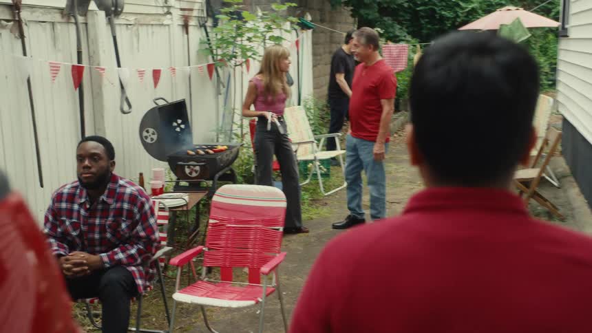 A man holding an invitation note is warmly welcomed by his neighbors as he joins their festive backyard barbecue party