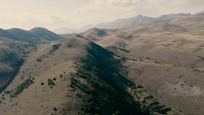 A beautiful aerial time-lapse of shadows dancing across the vast, arid hills and mountains of a remote landscape