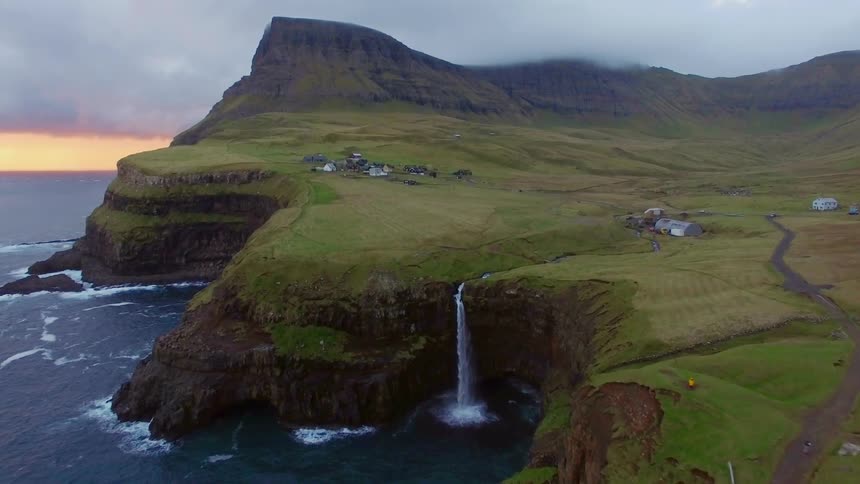 Small waterfall splashes off a cliff into the ocean