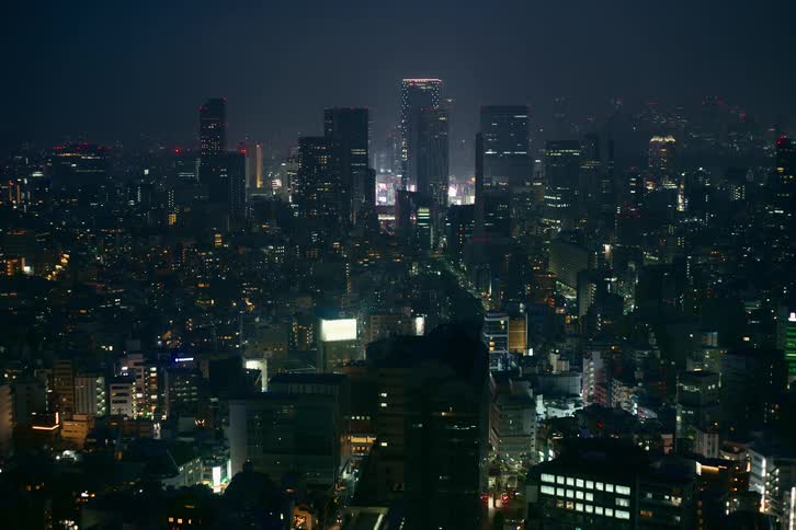 An expansive view of a major city's skyline glowing with countless lights under the dark night sky