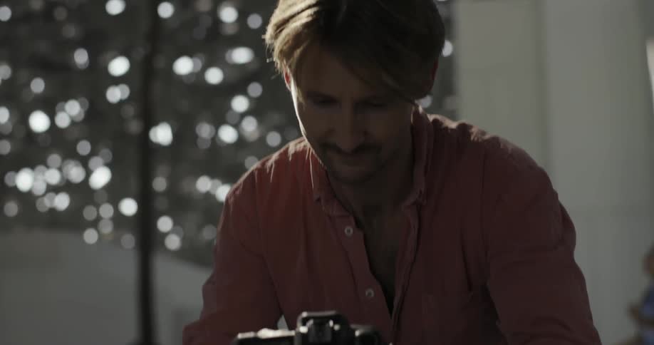 Man looks down at his camera