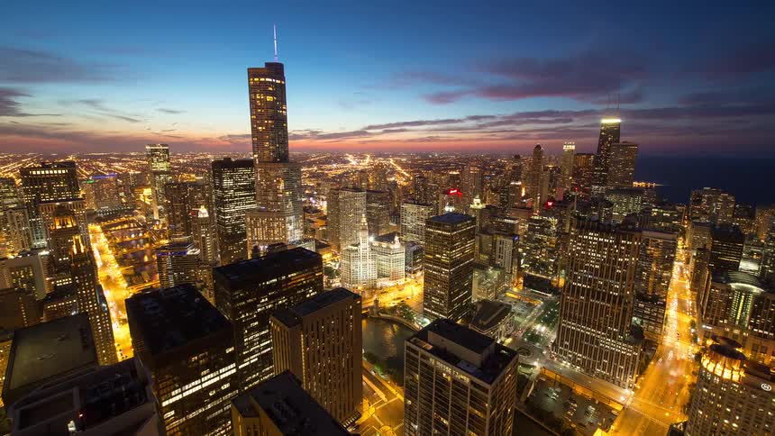 A breathtaking high-angle time-lapse of the Chicago skyline as the city transitions from a beautiful twilight into a bustling, illuminated night