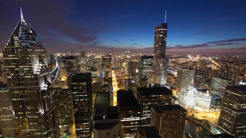 A stunning high-angle time-lapse of the Chicago cityscape at dusk, transitioning into night with glowing city lights and flowing traffic
