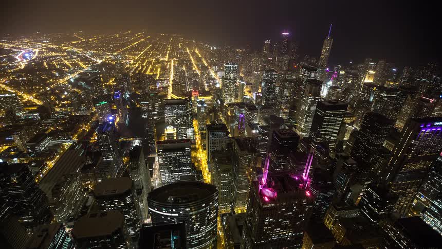 An expansive high-angle time-lapse of Chicago's downtown cityscape, brilliantly illuminated by streetlights and skyscrapers at night