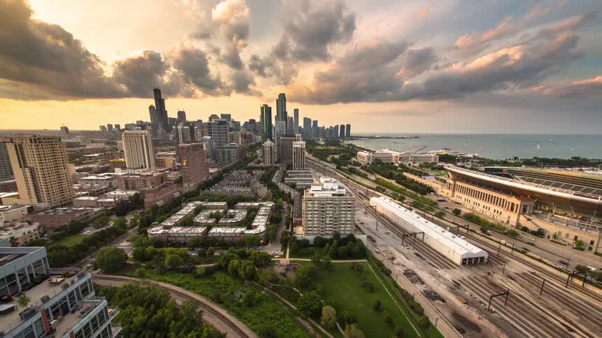 A dramatic sunset timelapse over the Chicago skyline, capturing the bustling city life with views of train tracks and Lake Michigan