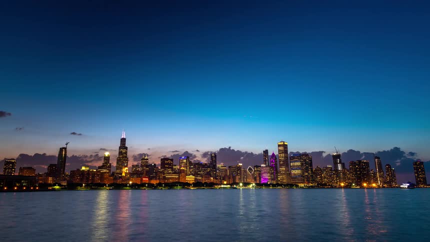 A beautiful day-to-night timelapse of the iconic Chicago skyline as the city lights up across Lake Michigan after sunset