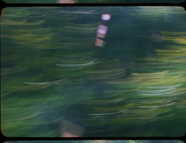 A vintage, dream-like view of the countryside with blurred green hills and yellow flowers passing by