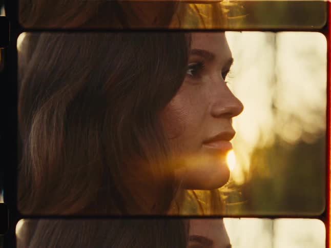 A close-up profile of a pensive woman's face framed in a nostalgic film strip style, who slowly opens her eyes and smiles during golden hour