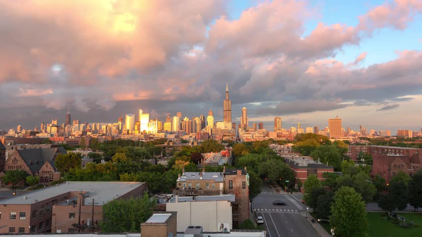 A beautiful time-lapse of the Chicago skyline during a dramatic golden hour sunset, with clouds rolling by and traffic moving below
