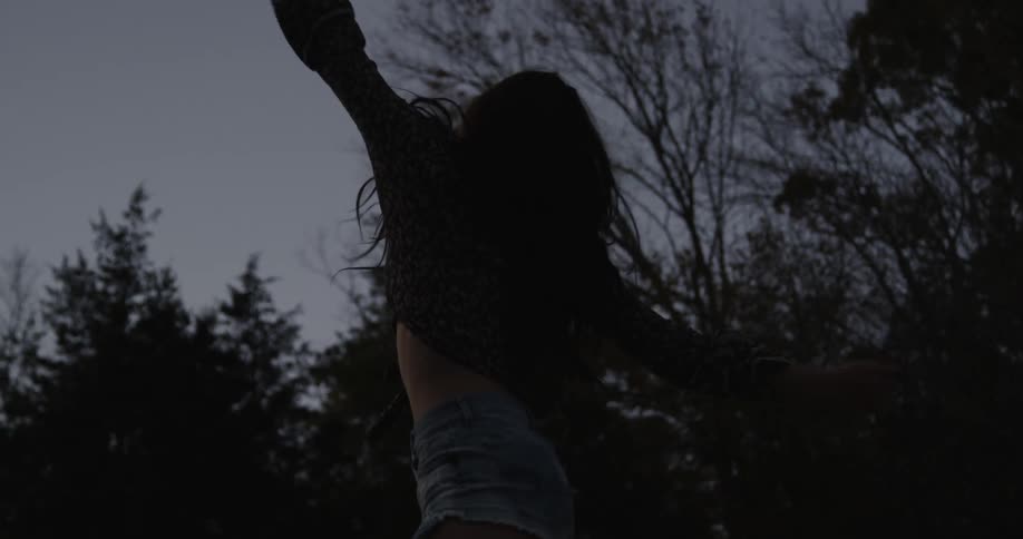 Silhouette of a woman dancing at night