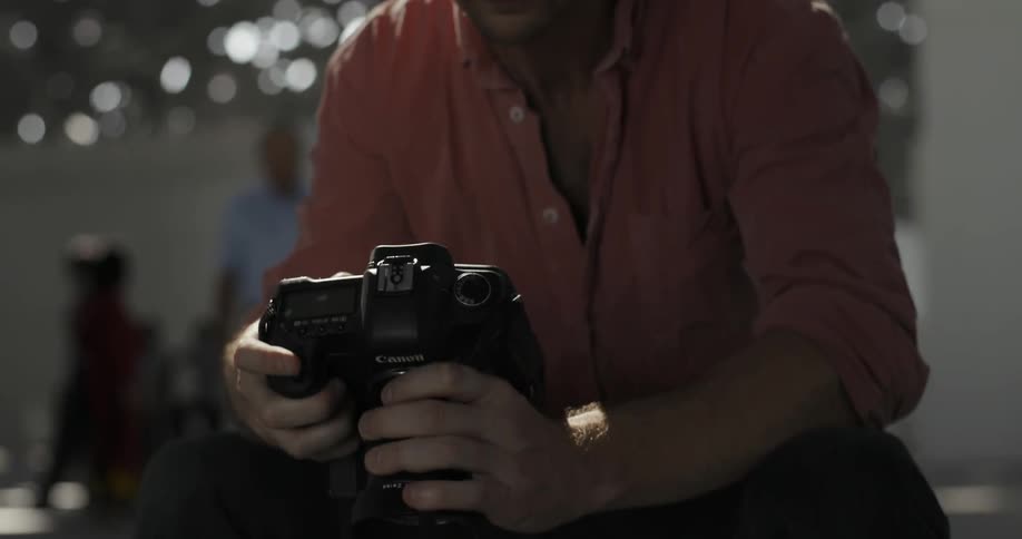 Man looks down at his camera