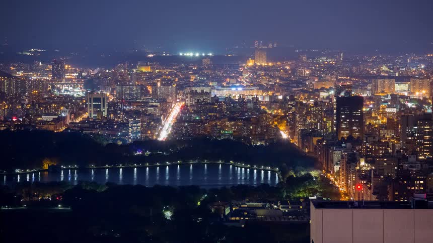 A stunning night time-lapse from a high angle overlooking the Jacqueline Kennedy Onassis Reservoir in Central Park, with the glowing lights of New York City in the background
