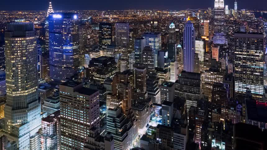A breathtaking aerial cinemagraph of the illuminated Manhattan skyline at night, with glittering lights from countless skyscrapers