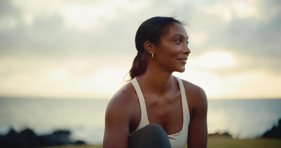 Portrait of a beautiful athletic African American woman smiling and enjoying the sunrise after a workout
