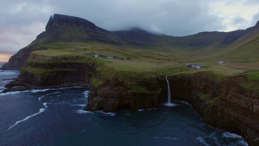 Small waterfall splashes off a cliff into the ocean