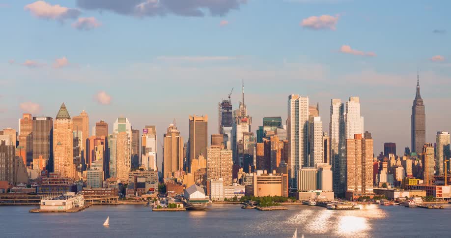 Golden hour time-lapse captures the Midtown Manhattan skyline as boats sail along the Hudson River at sunset