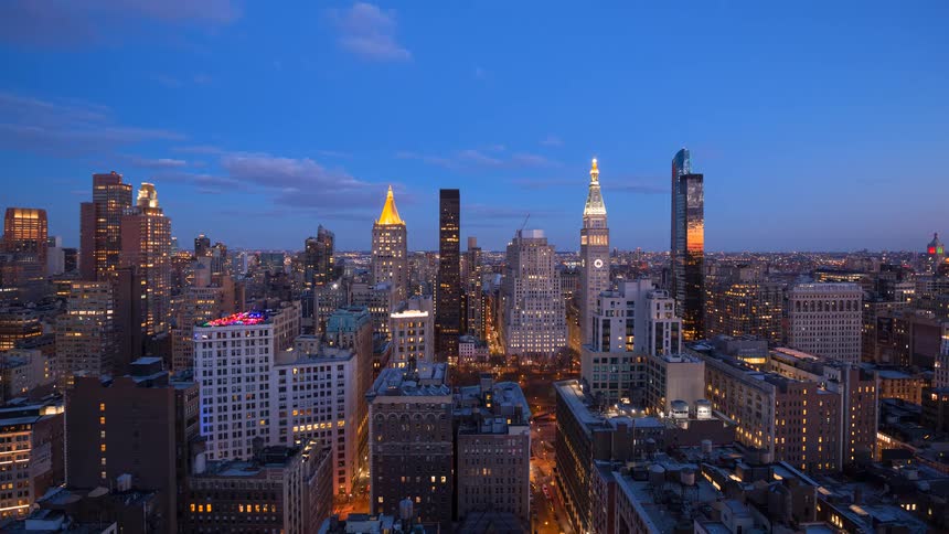 A stunning sunset-to-night timelapse over the bustling Manhattan cityscape, showing the transition from golden hour to illuminated night