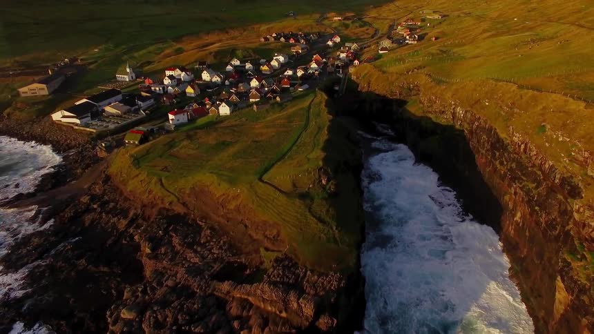 The waves crash against the rocks by this coastal town
