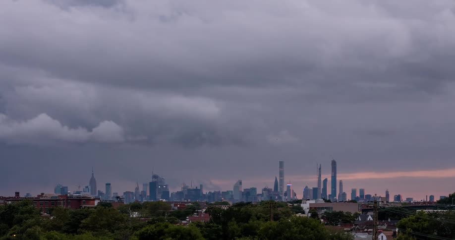 A day-to-night timelapse of the Midtown Manhattan skyline as a cloudy day transforms into a spectacularly vibrant pink and orange sunset