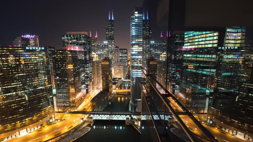 An epic night time-lapse of downtown Chicago reveals the bustling city life as traffic, trains, and boats create light trails through the illuminated urban canyon