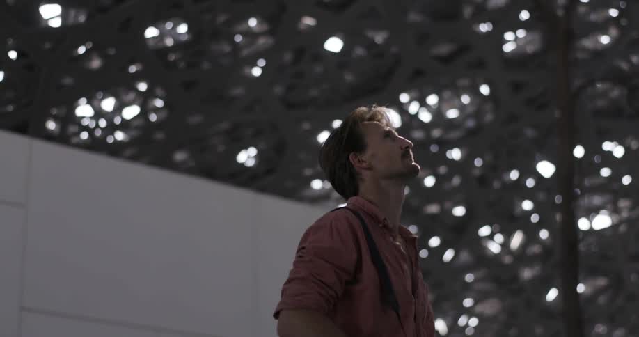 A man looks around at a structure overhead