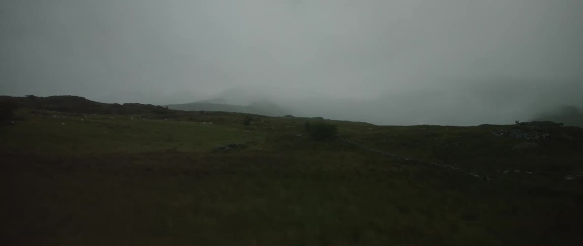 Time-lapse of mysterious fog rolling across a vast, moody, and green hilly landscape