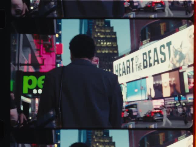 Vintage film captures a woman from behind as she walks through the bustling, neon-lit streets of Times Square at night
