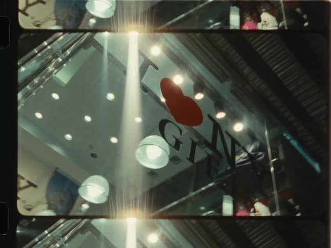 A vintage film montage shows a low-angle view of an 'I Love NY' gift shop sign and pedestrians crossing a busy city street at dusk