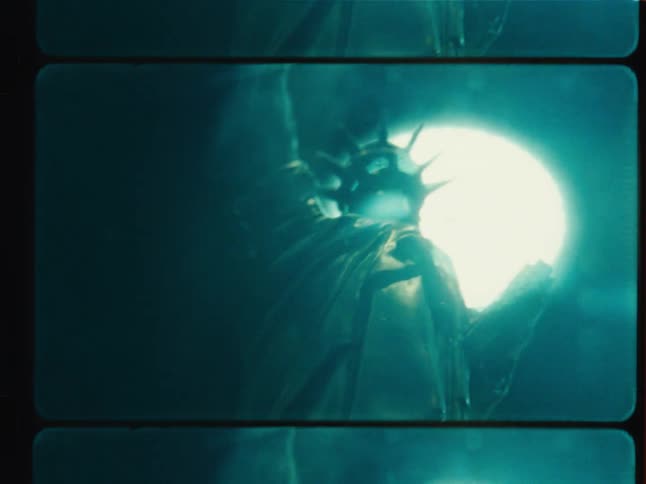 A moody close-up of a Statue of Liberty souvenir captured on grainy film with a dramatic blue light