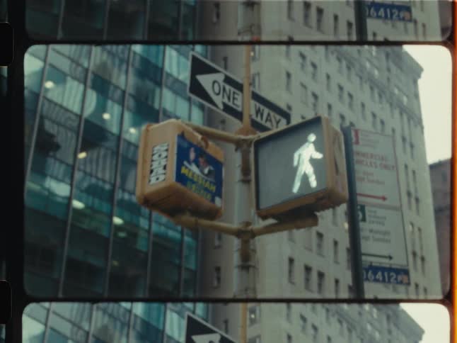 Vintage multi-frame footage captures close-ups of pedestrian walk and don't walk signals on a New York City street corner