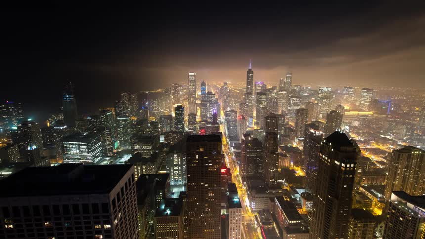 An epic time-lapse of the Chicago skyline at night as fog and clouds roll over the brightly illuminated city streets and skyscrapers